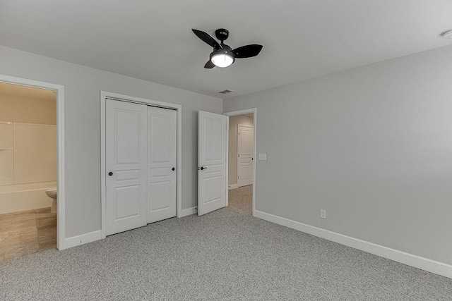 unfurnished bedroom featuring a closet, light colored carpet, connected bathroom, and baseboards