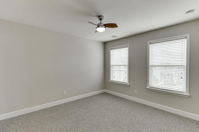 spare room with light carpet, visible vents, baseboards, and ceiling fan