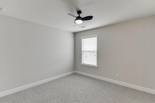 spare room featuring visible vents, ceiling fan, light colored carpet, and baseboards