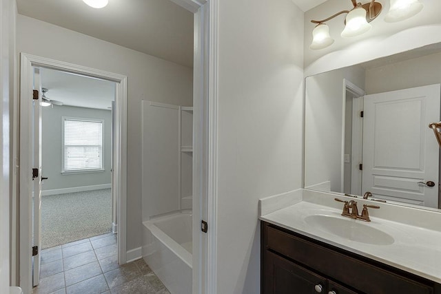 bathroom featuring baseboards, a tub to relax in, vanity, and tile patterned flooring