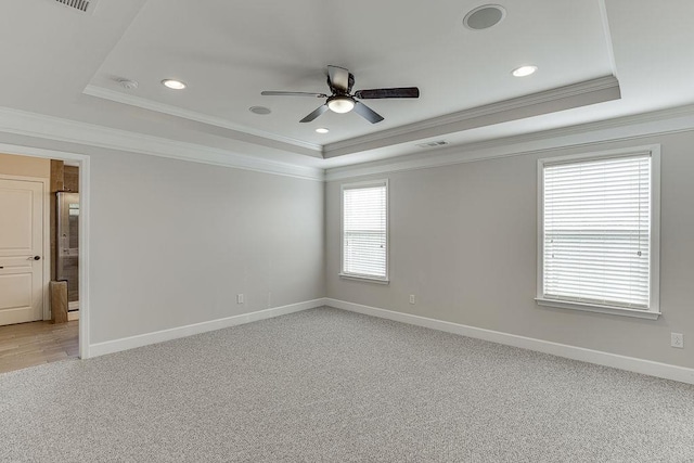 unfurnished room featuring a raised ceiling, a ceiling fan, baseboards, and visible vents