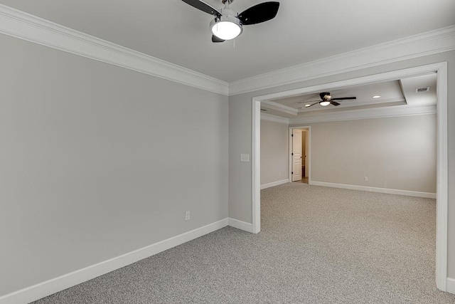 unfurnished room with a tray ceiling, crown molding, baseboards, light colored carpet, and ceiling fan