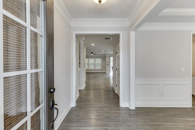 hall featuring a wainscoted wall, wood finished floors, and crown molding