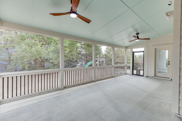 unfurnished sunroom featuring a ceiling fan and vaulted ceiling