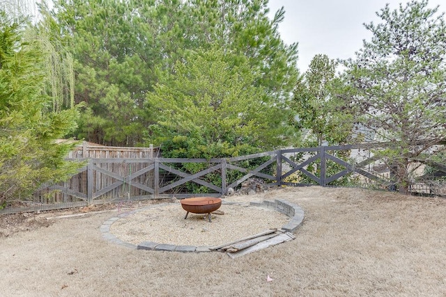 view of yard with a gate, an outdoor fire pit, and fence