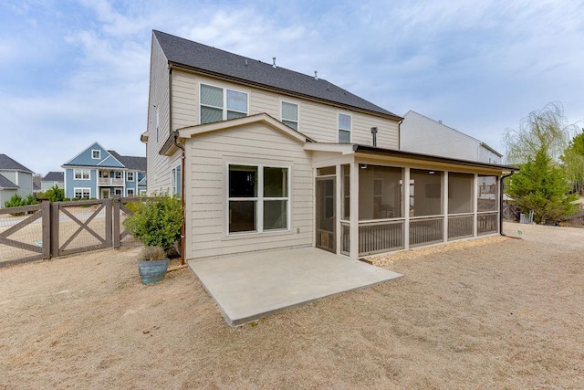 rear view of property featuring a patio, fence, and a sunroom