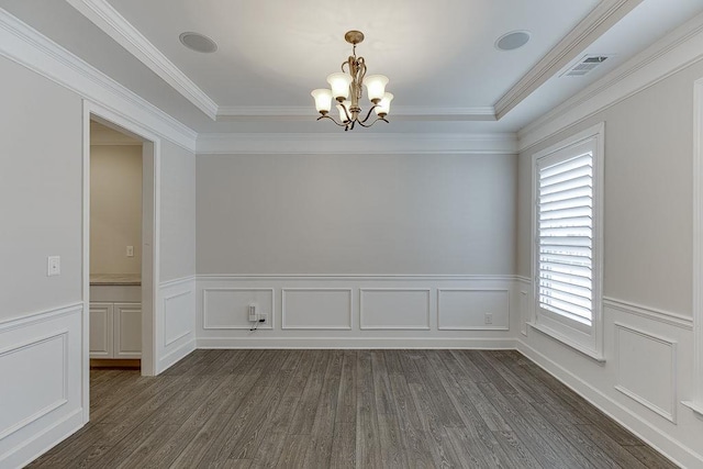 empty room featuring visible vents, ornamental molding, wainscoting, a notable chandelier, and dark wood-style flooring