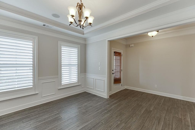 spare room with dark wood finished floors, a notable chandelier, visible vents, and ornamental molding