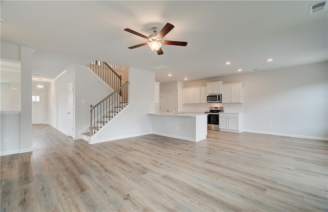 unfurnished living room featuring ceiling fan and light hardwood / wood-style flooring