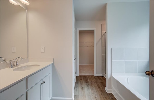 bathroom featuring a bath, hardwood / wood-style flooring, and large vanity