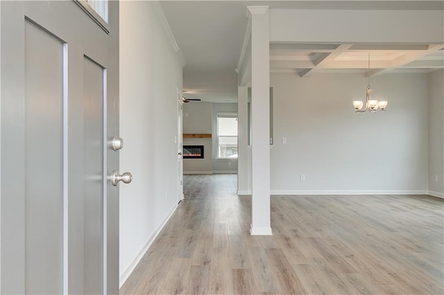 interior space featuring light hardwood / wood-style floors, crown molding, an inviting chandelier, beamed ceiling, and coffered ceiling