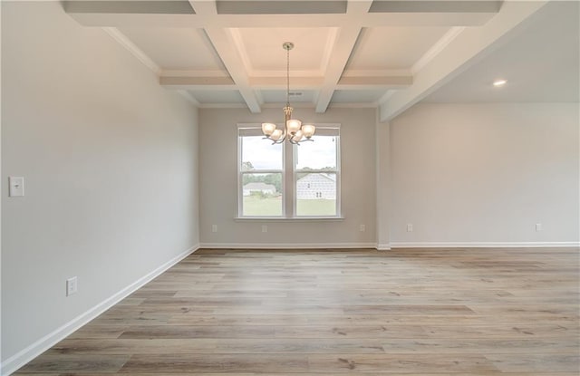 empty room featuring beamed ceiling, a chandelier, coffered ceiling, and hardwood / wood-style floors