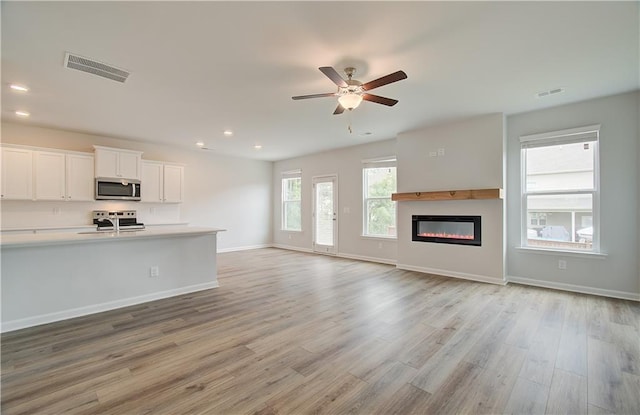 interior space featuring ceiling fan, sink, and light hardwood / wood-style flooring