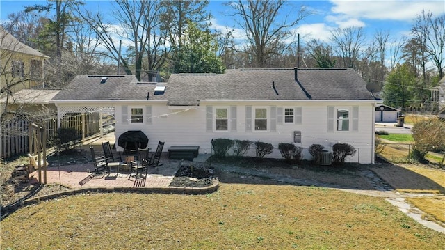 rear view of house with central AC, a yard, and a patio area