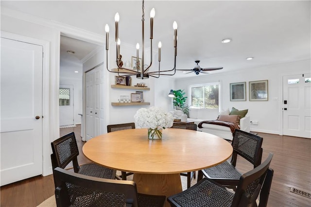 dining area featuring ornamental molding, dark hardwood / wood-style flooring, and ceiling fan with notable chandelier