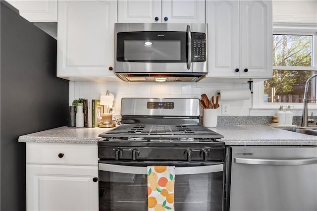 kitchen with sink, white cabinets, tasteful backsplash, and appliances with stainless steel finishes