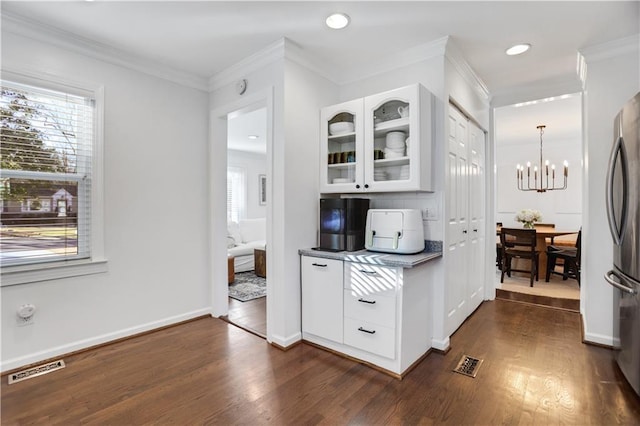 kitchen featuring stainless steel refrigerator, dark wood-type flooring, backsplash, and white cabinetry