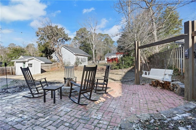 view of patio with a storage unit and a fire pit