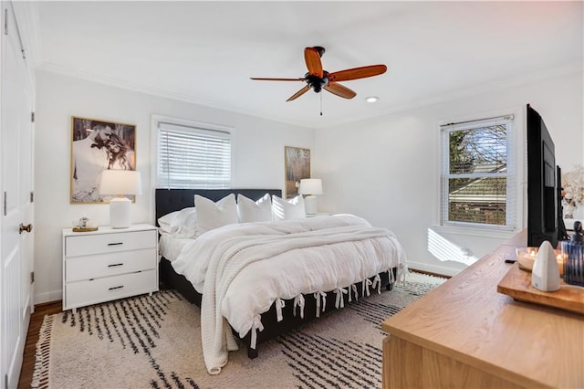 bedroom featuring ceiling fan, ornamental molding, and light hardwood / wood-style flooring