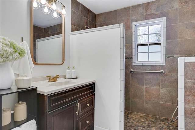 bathroom featuring a tile shower and vanity