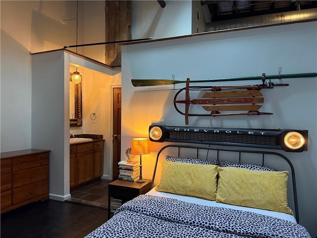 bedroom featuring ensuite bathroom, baseboards, and a sink