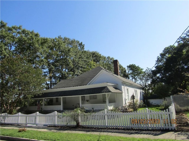 view of side of property featuring covered porch