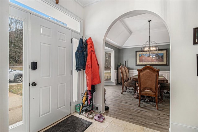 tiled foyer with plenty of natural light, arched walkways, and ornamental molding