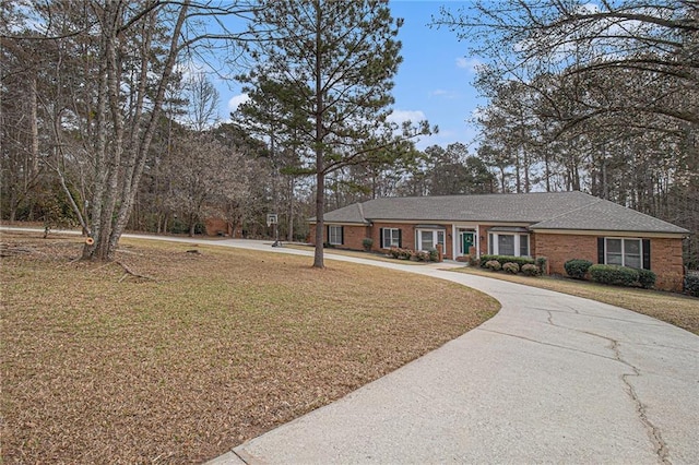 single story home with driveway, a front lawn, and brick siding