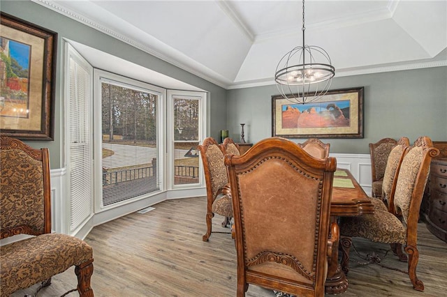 dining room featuring ornamental molding, a chandelier, a wainscoted wall, and wood finished floors