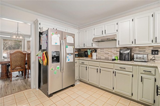 kitchen featuring backsplash, light tile patterned flooring, stainless steel fridge, under cabinet range hood, and black electric cooktop