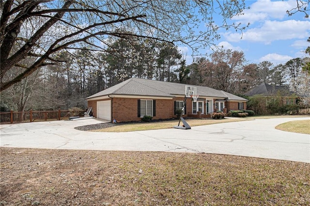 view of front of home featuring brick siding, concrete driveway, an attached garage, fence, and a front yard