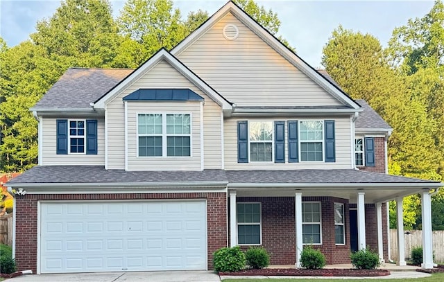 5421 Skylar Creek Ln, Buford, GA 30518 - view of front of home with a porch, brick siding, driveway, and an attached garage