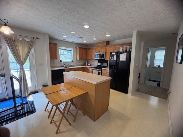 5421 Skylar Creek Ln, Buford, GA 30518 - kitchen with black appliances, light countertops, a kitchen island, brown cabinets, and light flooring