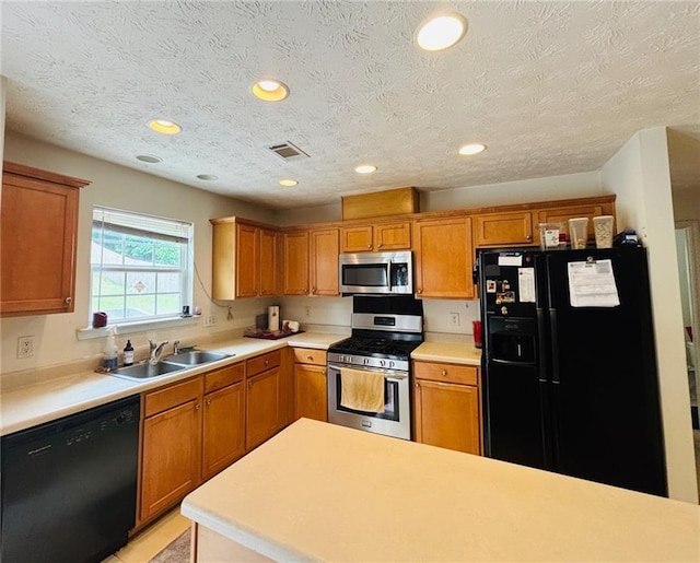 5421 Skylar Creek Ln, Buford, GA 30518 - kitchen with black appliances, light countertops, brown cabinets, recessed lighting, and a textured ceiling