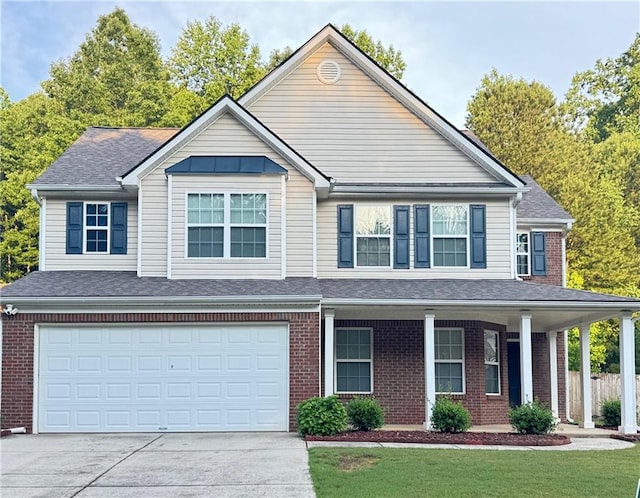 5421 Skylar Creek Ln, Buford, GA 30518 - view of front of house featuring driveway, a garage, brick siding, a porch, and a shingled roof