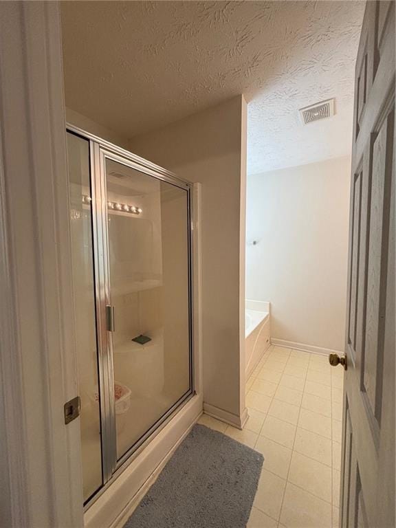 5421 Skylar Creek Ln, Buford, GA 30518 - bathroom featuring a shower stall, a bath, tile patterned floors, and a textured ceiling