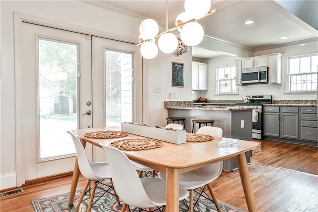 1136 Moreland Pl SE, Atlanta, GA 30316 - dining area featuring ornamental molding, wood finished floors, healthy amount of natural light, and a chandelier