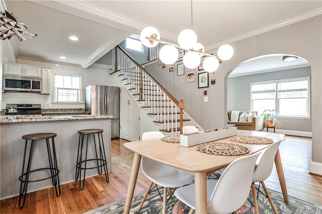 1136 Moreland Pl SE, Atlanta, GA 30316 - dining room featuring ornamental molding, arched walkways, light wood-type flooring, stairway, and recessed lighting