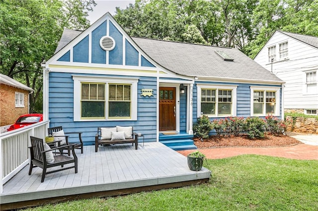 1136 Moreland Pl SE, Atlanta, GA 30316 - tudor-style house with a front yard, a deck, an outdoor living space, and roof with shingles