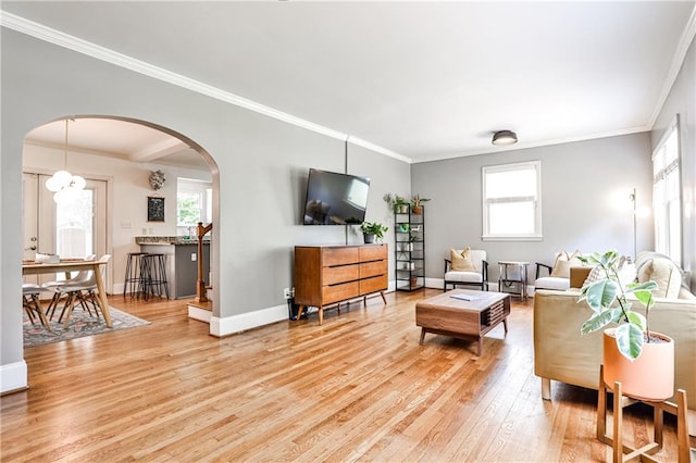 1136 Moreland Pl SE, Atlanta, GA 30316 - living room featuring light wood-style floors, arched walkways, ornamental molding, and baseboards