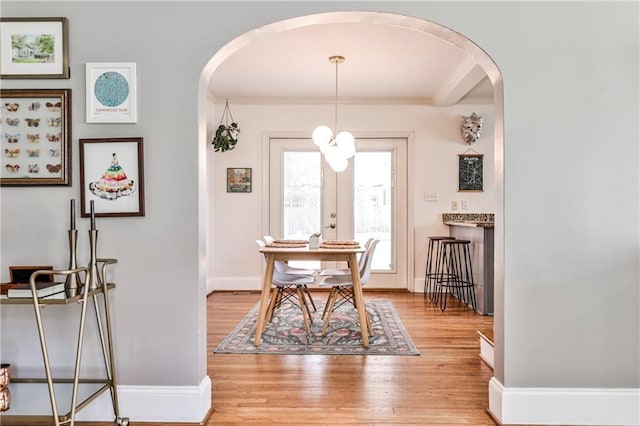1136 Moreland Pl SE, Atlanta, GA 30316 - dining space with arched walkways, light wood-style flooring, ornamental molding, and baseboards