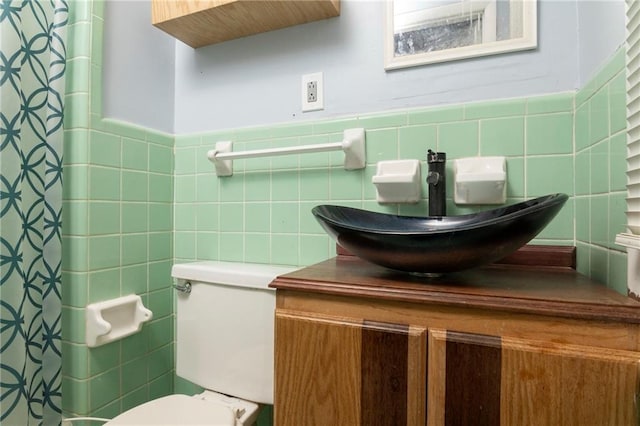 bathroom featuring a shower with shower curtain, tile walls, toilet, and vanity