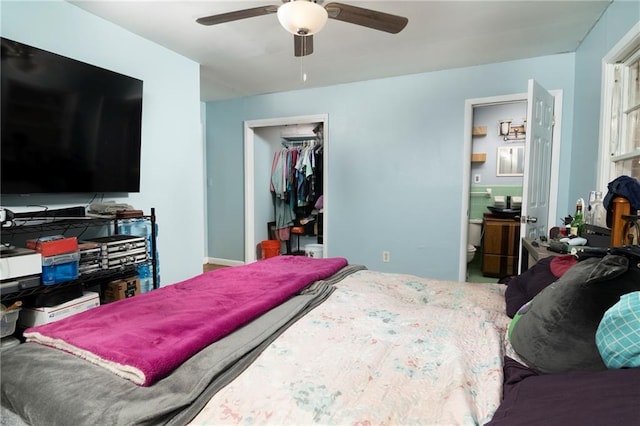 bedroom featuring a ceiling fan, a closet, and ensuite bath