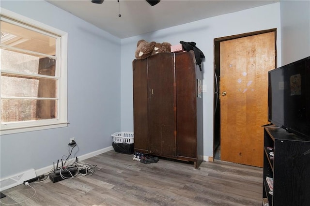 bedroom featuring a ceiling fan, visible vents, baseboards, and wood finished floors