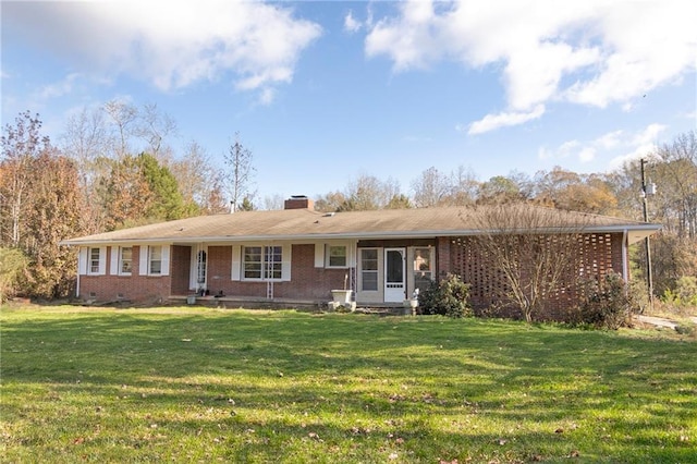 ranch-style house featuring brick siding, crawl space, a chimney, and a front yard