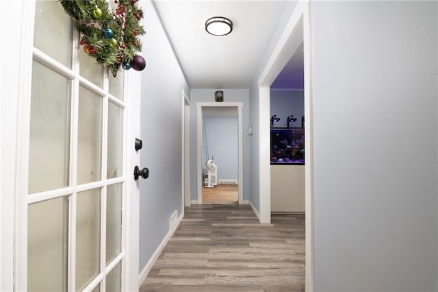 hall with baseboards and light wood finished floors