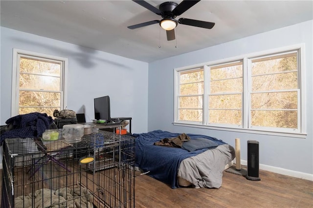 bedroom with wood finished floors, a ceiling fan, and baseboards