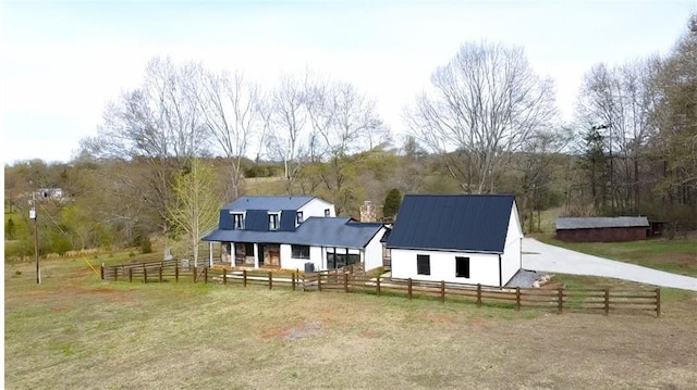 exterior space with fence, a barn, an outbuilding, and metal roof