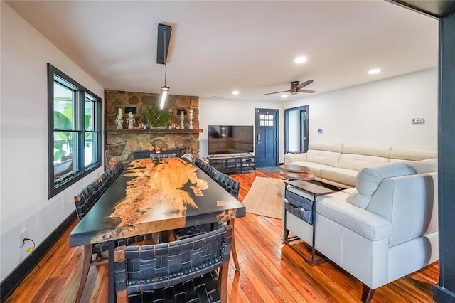 rec room with a ceiling fan, wood finished floors, recessed lighting, and a stone fireplace