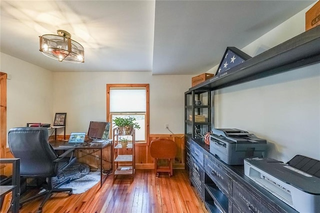 office area with light wood-type flooring and a wainscoted wall